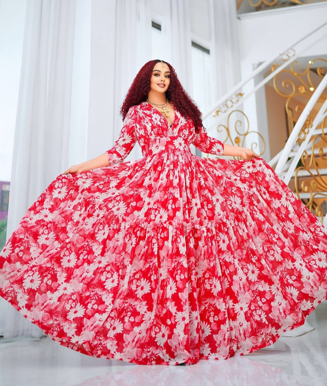 Woman wearing a red and white Habesha Shiffon in an elegant interior setting.