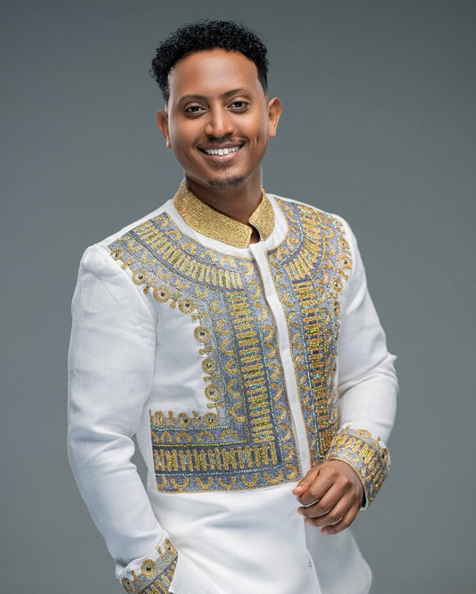 Man wearing a Habesha Men’s Shirt with gold details on a gray background