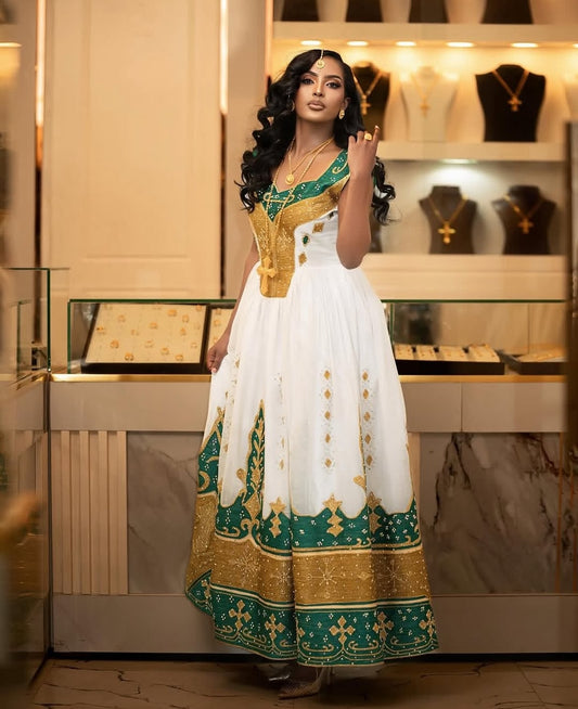 Woman in a traditional Green Habesha Kemis with gold and green patterns in a jewelry store.