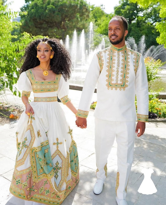 Couple in traditional Green Ethiopian Traditional Couple Set standing outdoors with a fountain in the background