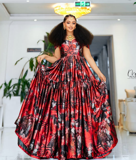 Woman in a red and black floral dress posing indoors.