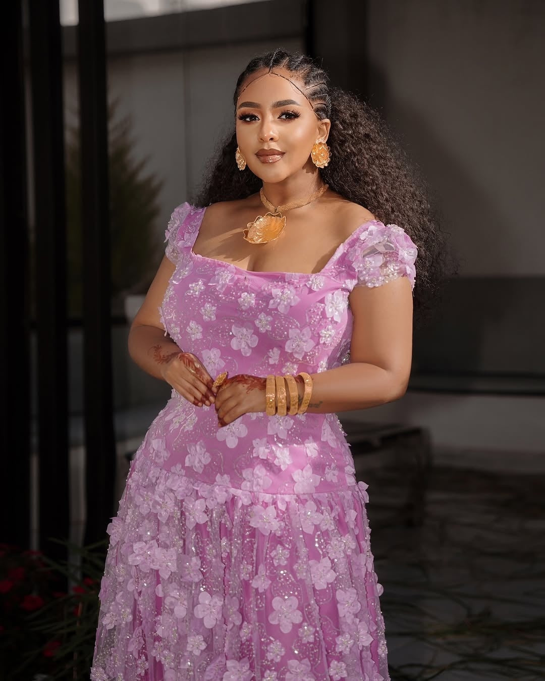 Woman in a pink floral Habesha Shiffon posing indoors