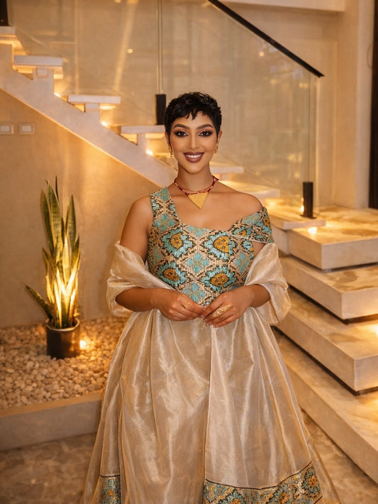 Woman in a traditional Habesha Libs standing in a modern indoor setting with stairs and decorative elements.