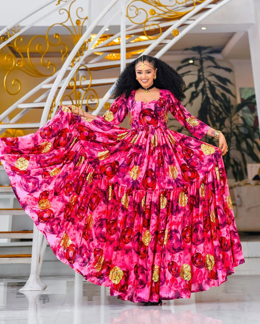 Woman in a vibrant pink Habesha chiffion with gold patterns standing in a decorated interior setting.
