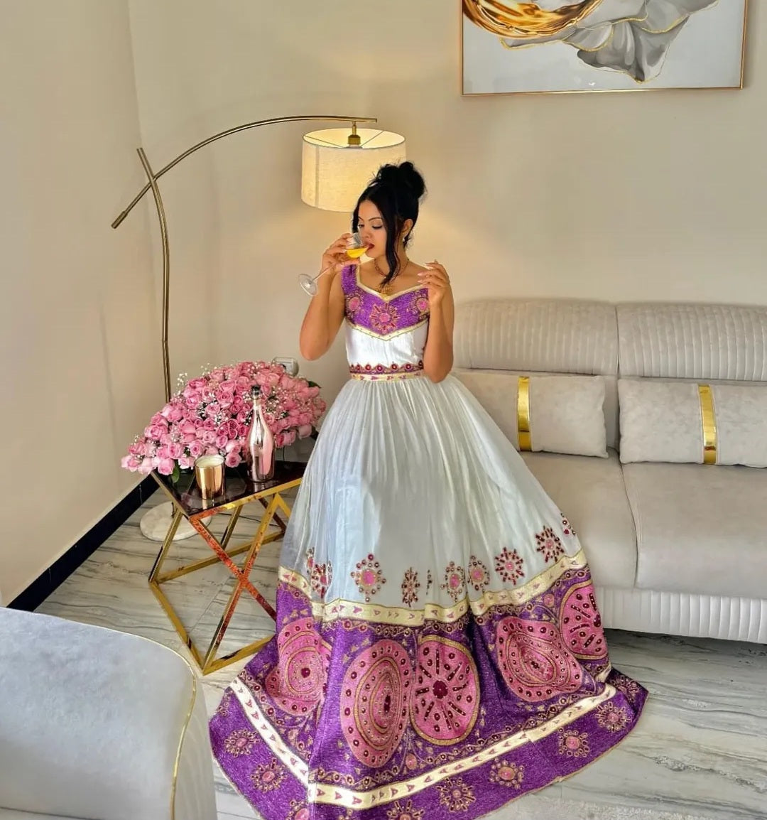 A woman wearing a modern habesha dress made by a habesha designer for a wedding