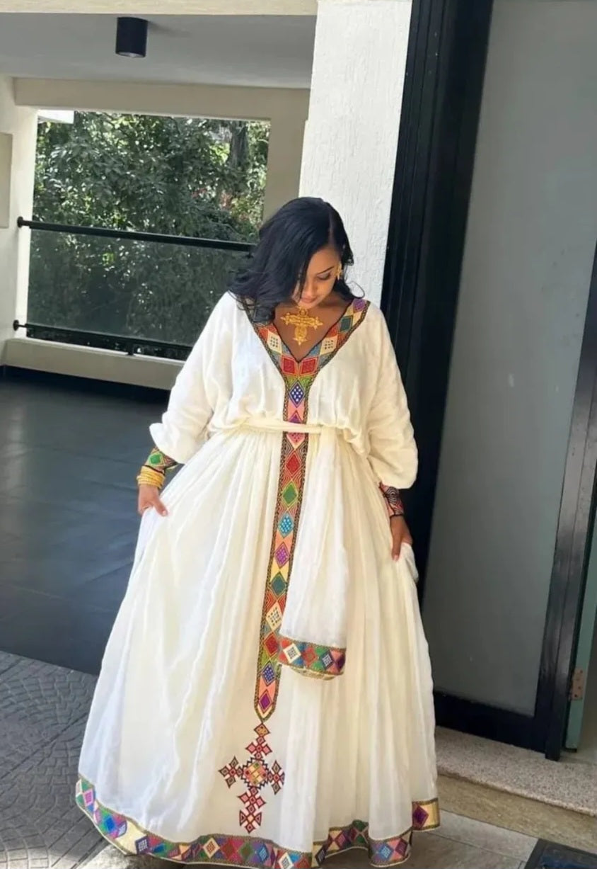 A young woman wearing a Habesha kemis showing the beauty of Habesha traditional dresses