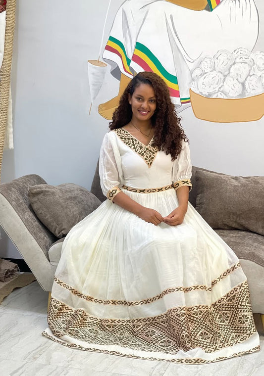 A woman wearing a Habesha dress with different Habesha dress ideas incorporated within it
