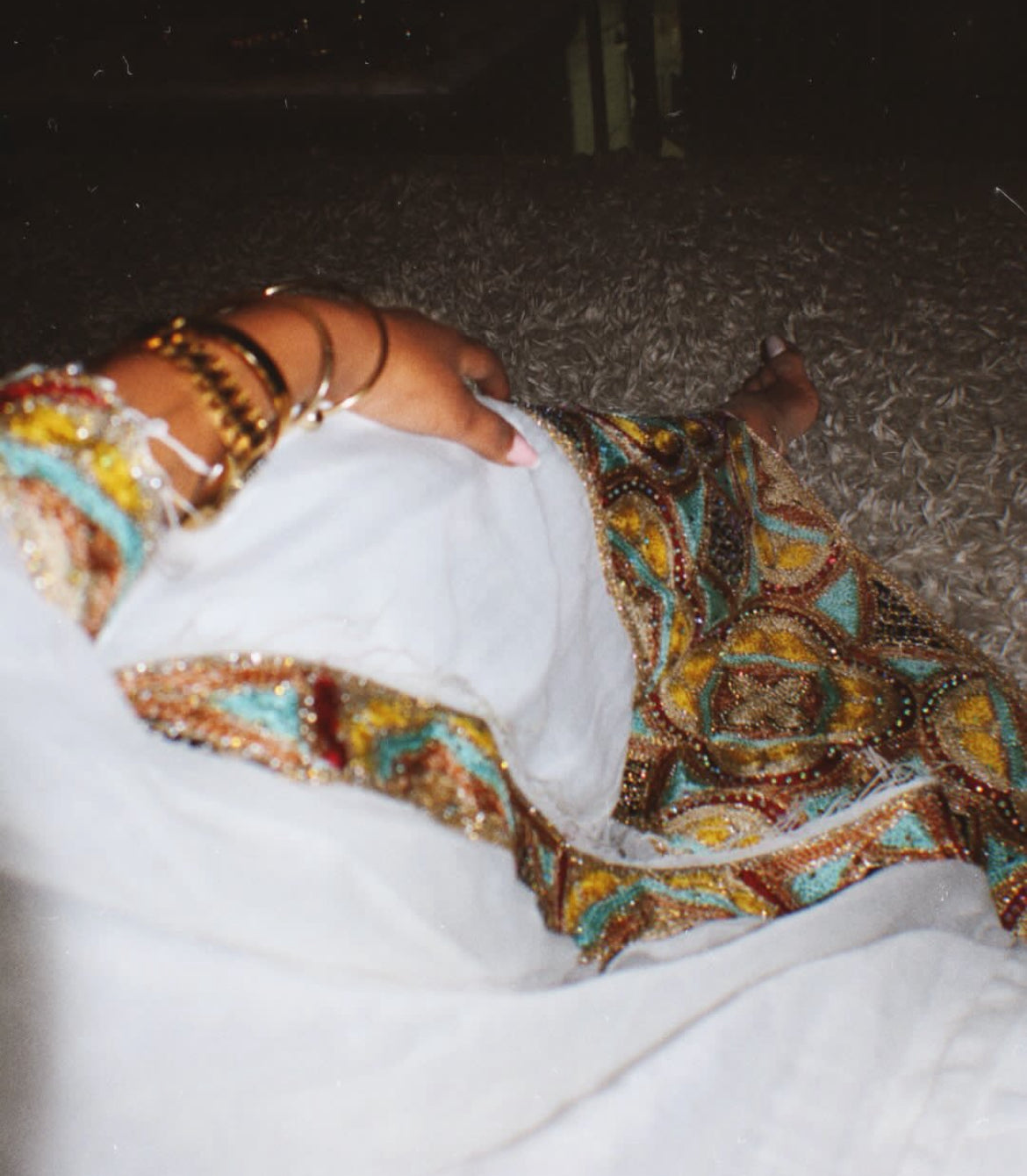 Person wearing a colorful Habesha Zuria beaded garment in a snowy outdoor setting