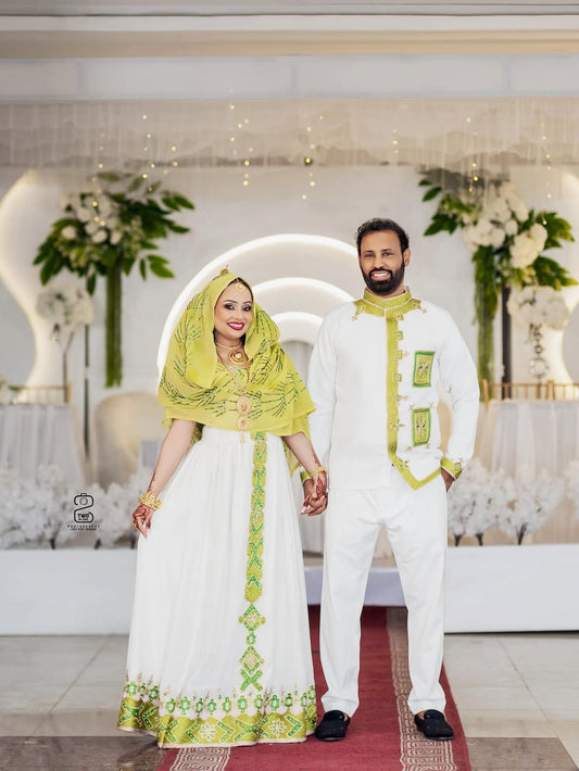 Couple in traditional Habesha Couple Wedding Dress standing in a decorated indoor setting
