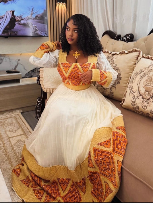 Woman in a traditional outfit sitting on a couch in a living room.