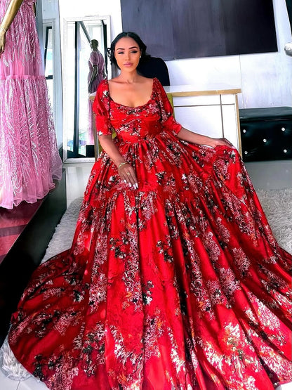 Woman wearing a red floral Shiffon Habesha in a room with pink dresses in the background