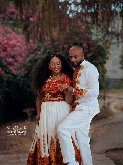 Couple in traditional Red and White Habesha Matching Couple Set standing outdoors with pink flowers in the background