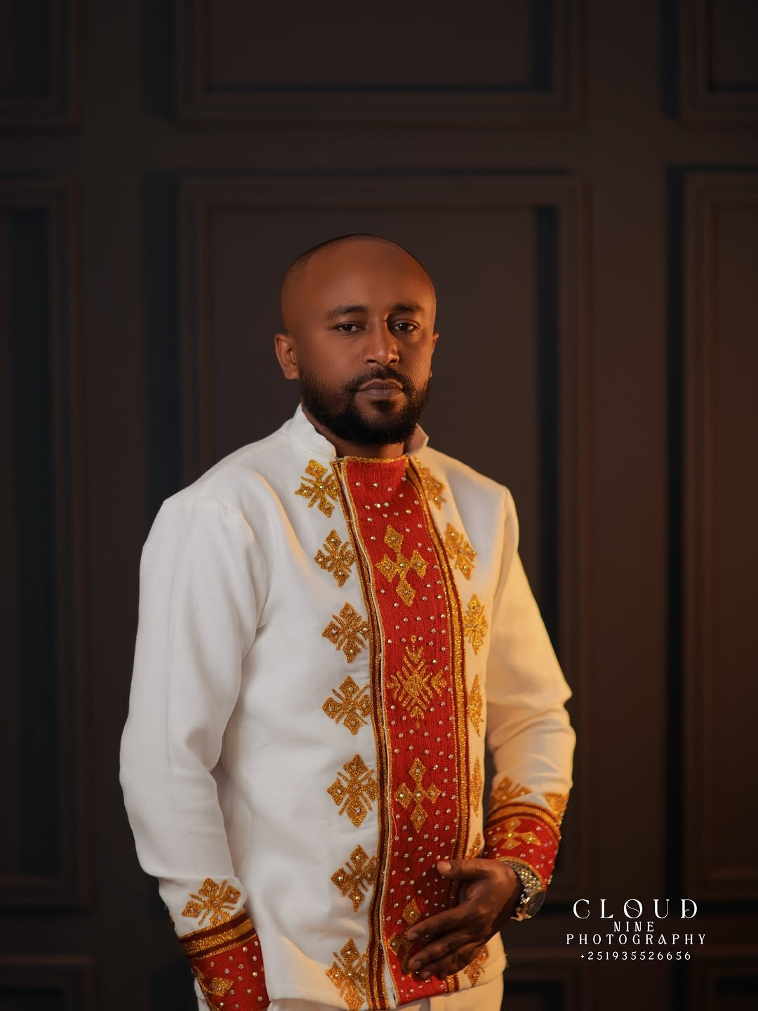Man wearing a traditional Red and White Habesha Matching Couple Set with intricate designs against a dark background