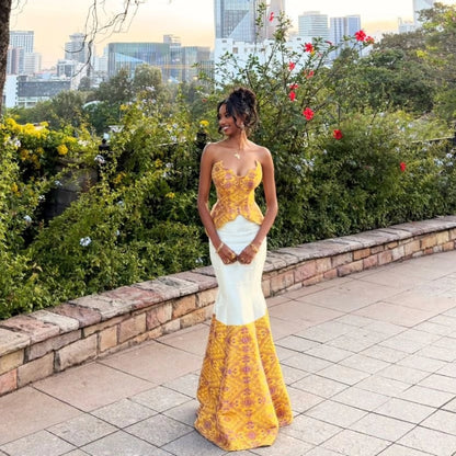 Woman posing outdoors in a strapless modern Habesha dress featuring a yellow woven patterned peplum bodice and a white skirt with a matching detailed yellow hem.