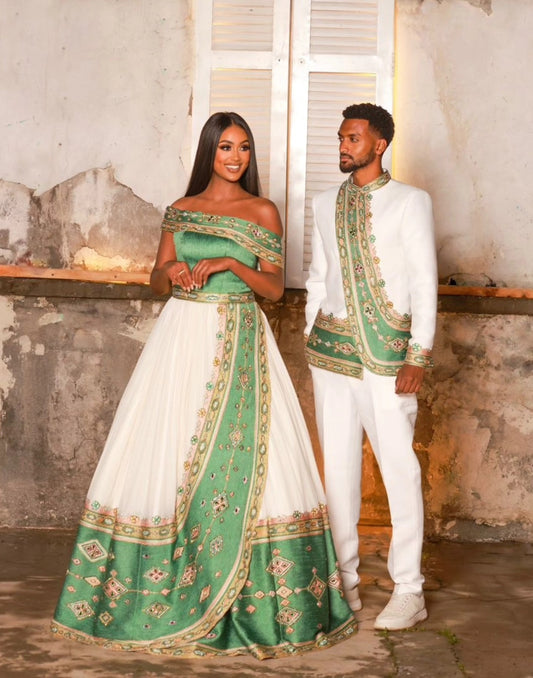 Man and woman in formal Ethiopian Traditional matching couple outfit standing in a rustic indoor setting.