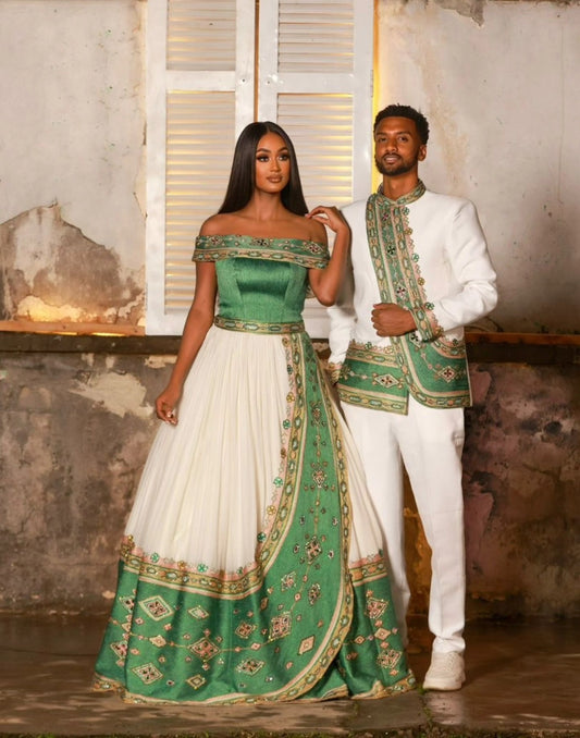 Man and woman in formal Ethiopian Traditional matching couple outfit with green and white outfits standing in a rustic setting.