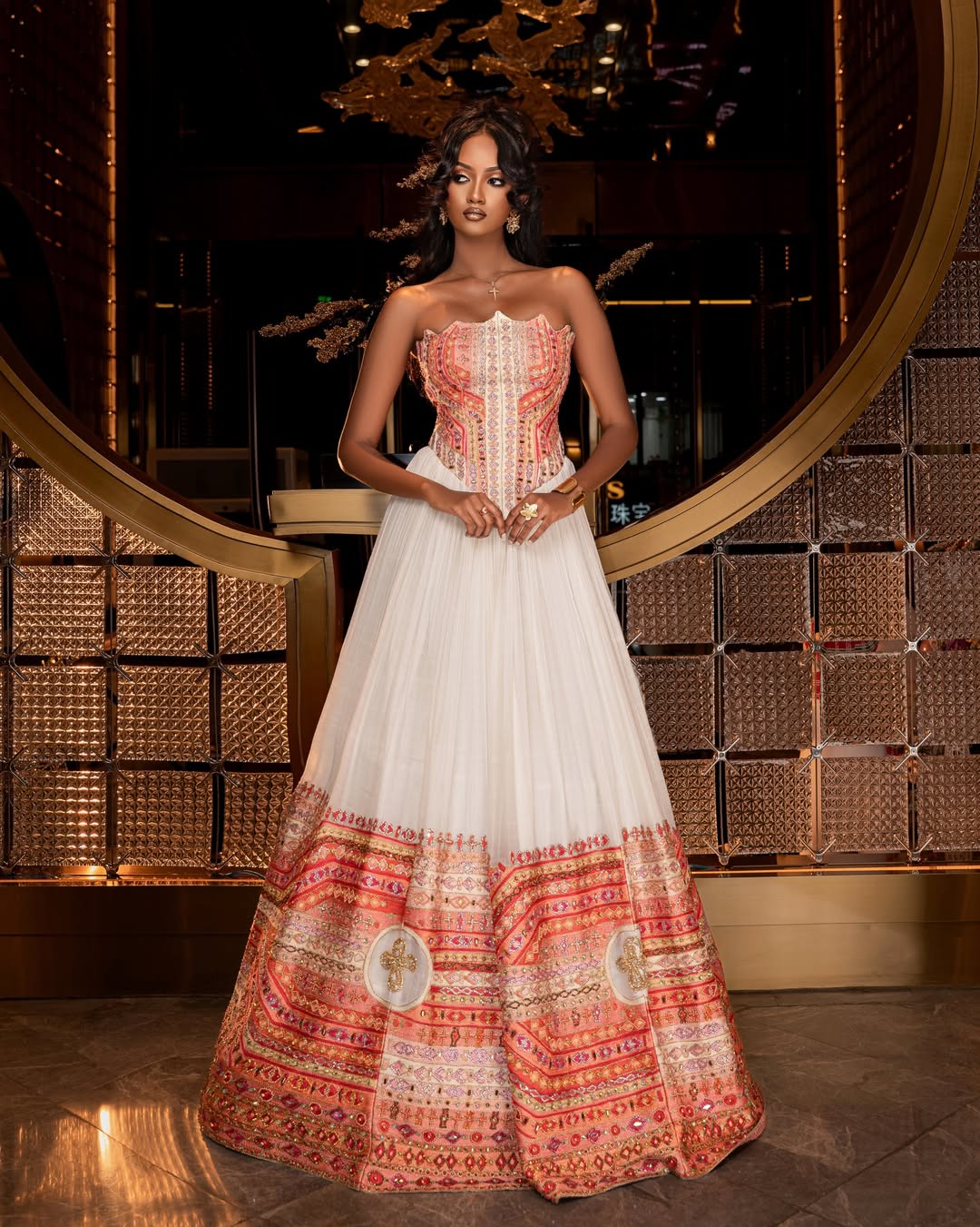Woman wearing a traditional Ethiopian traditional dress  with intricate patterns in a decorative setting