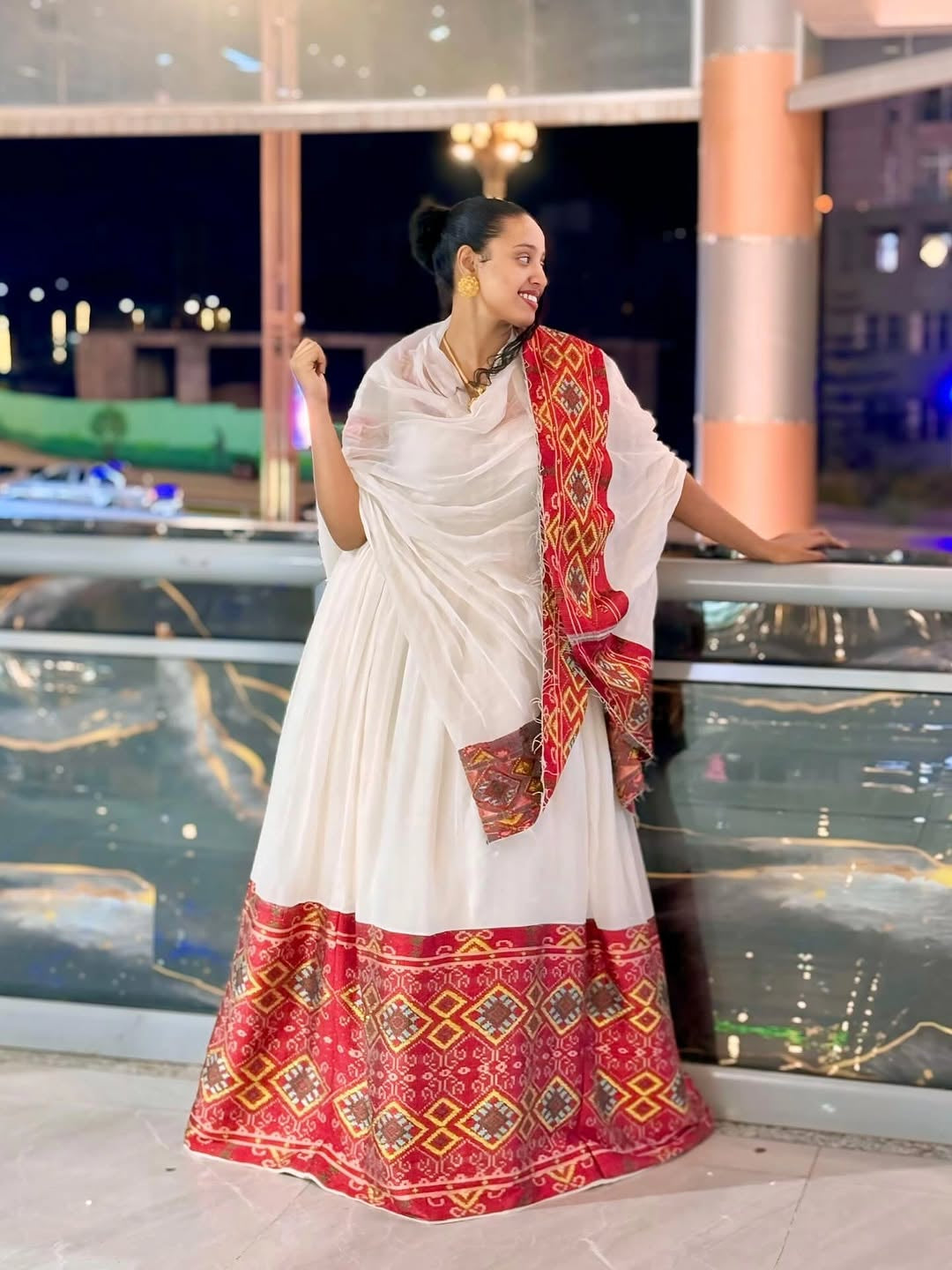 Woman in a white and red Ethiopian Dress with a scenic background