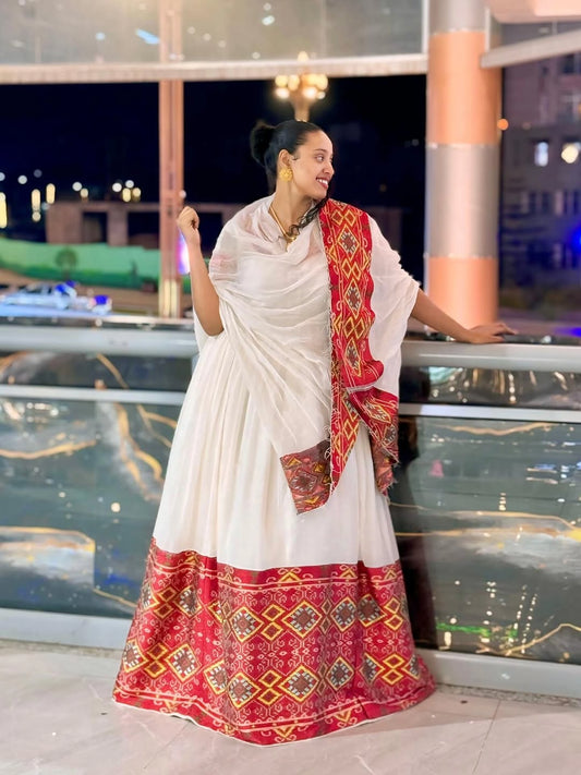 Woman in a white and red Ethiopian Dress with a scenic background