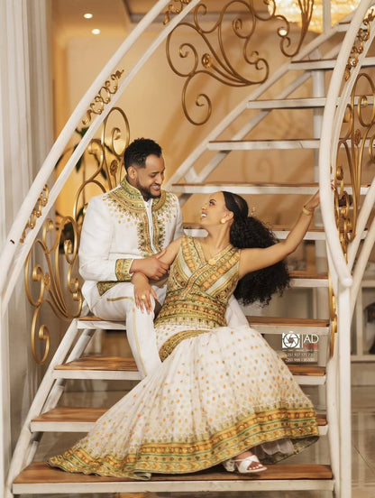 Couple in forma Habesha Men’s Wedding Outfit attire sitting on a decorative staircase