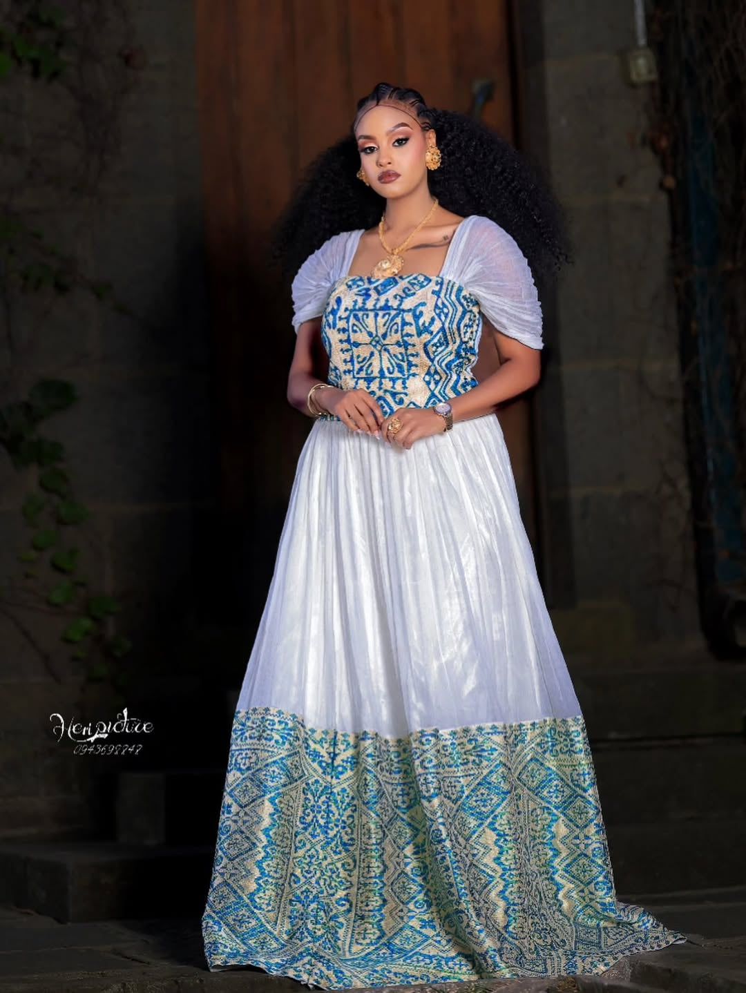 Woman wearing a Ethiopian traditional dress with a blue and white patterned dress.
