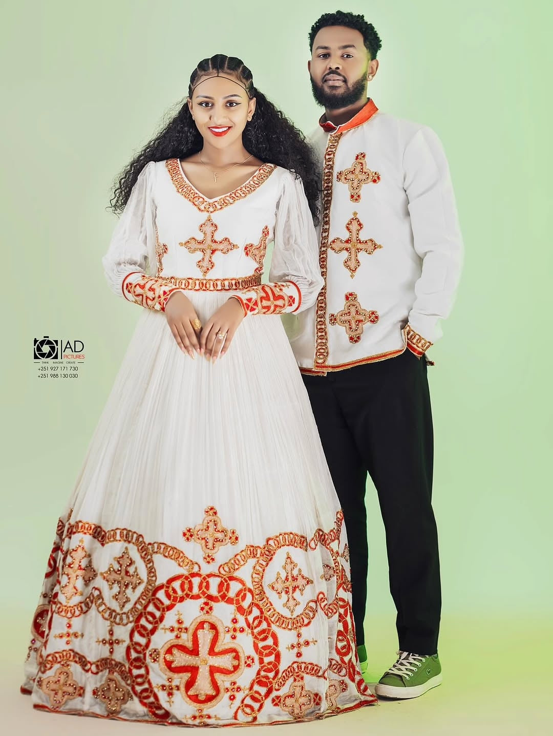 Couple wearing traditional embroidered habesha dress on a light green background
