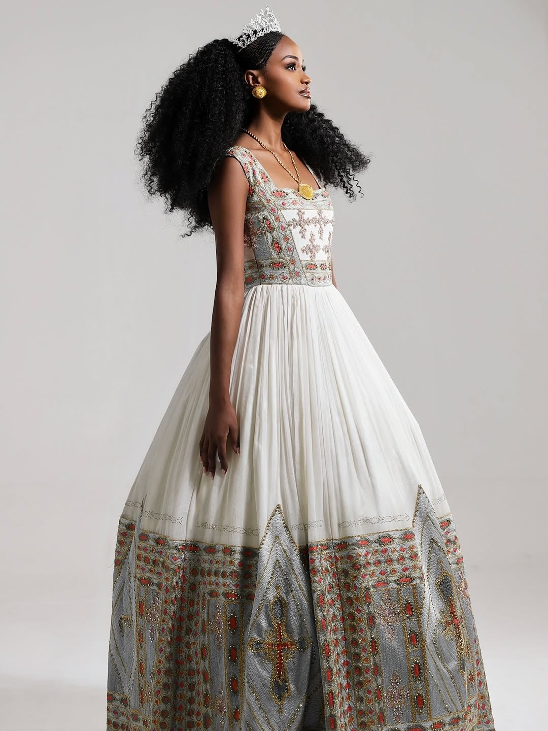 Woman wearing a long, patterned Eritrean Libs –  with a white background