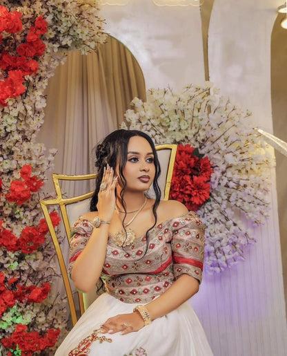 Woman in a Habesha Wedding  Dress decorated setting with flowers and a mirror