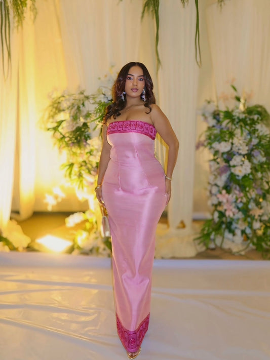Woman in a pink strapless Habesha kemis  with floral decorations in the background