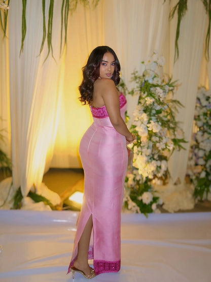 Woman in a pink Habesha kemis  standing in front of floral decorations