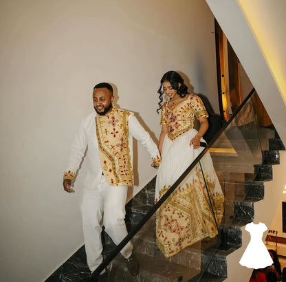 Man and woman in Ethiopian traditional wedding attire walking down a staircase.