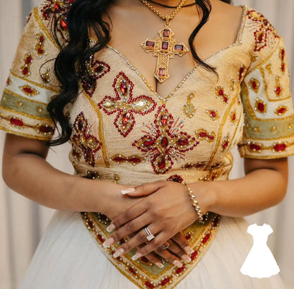 Woman wearing a intricately designed Ethiopian traditional dress with floral patterns and a cross pendant necklace.