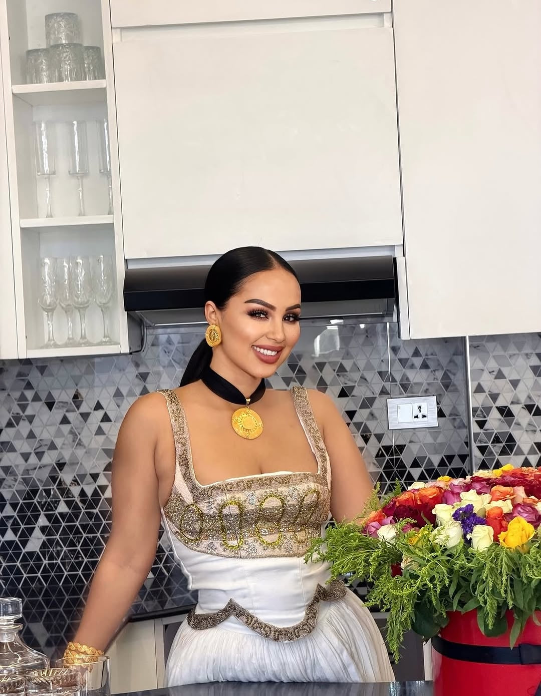 Woman in a kitchen dressing Ethiopia traditional dress with a decorative background