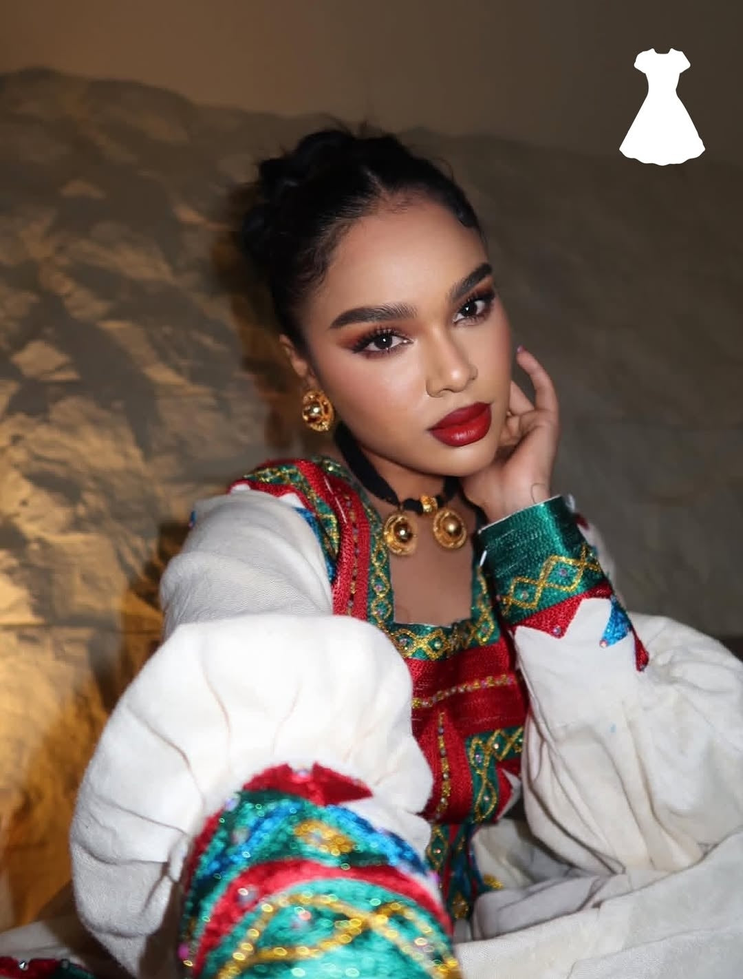 Woman wearing a colorful traditional Ethiopia traditional dress with a plain background
