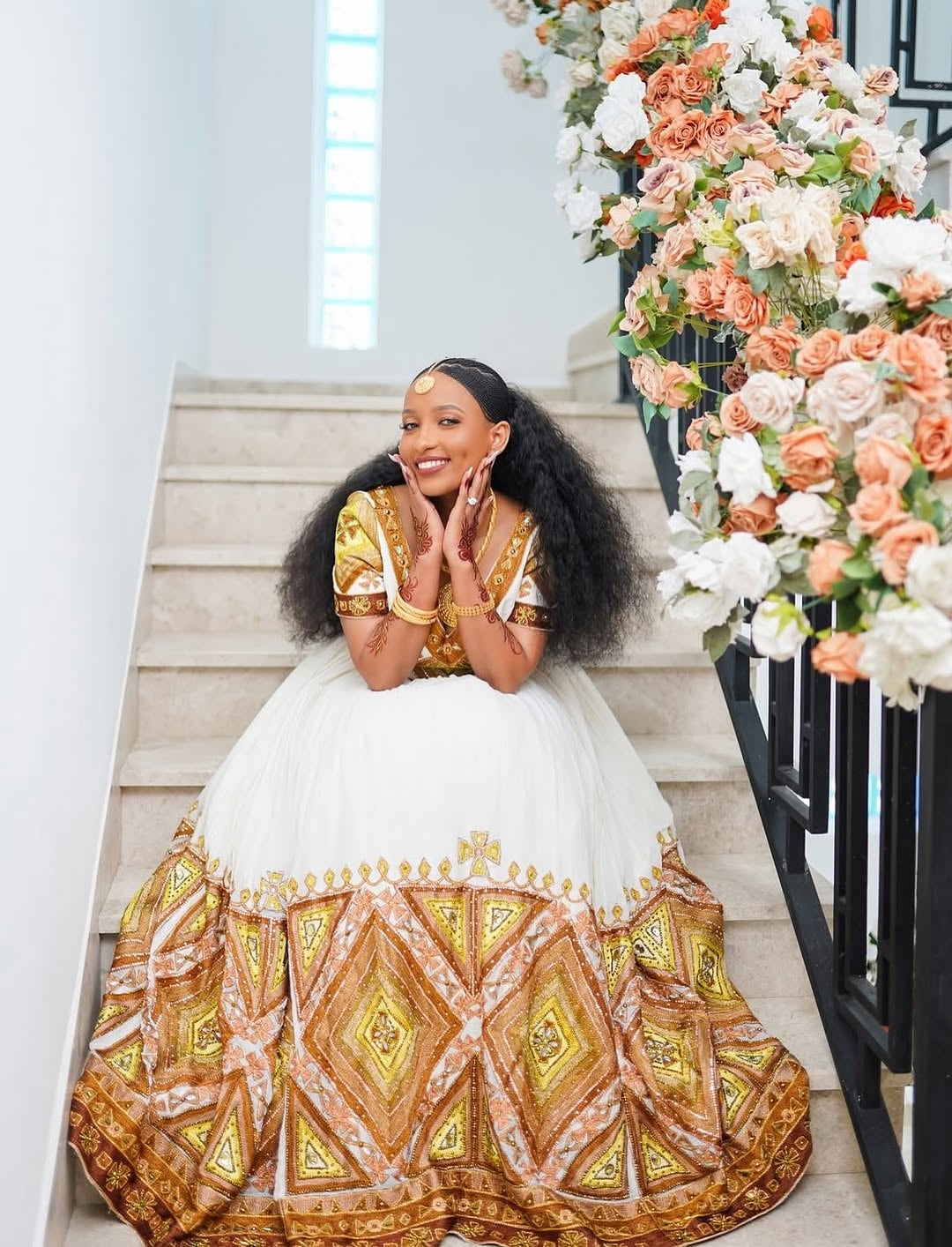 Woman in a Ethiopia traditional dress sitting on stairs with floral decorations