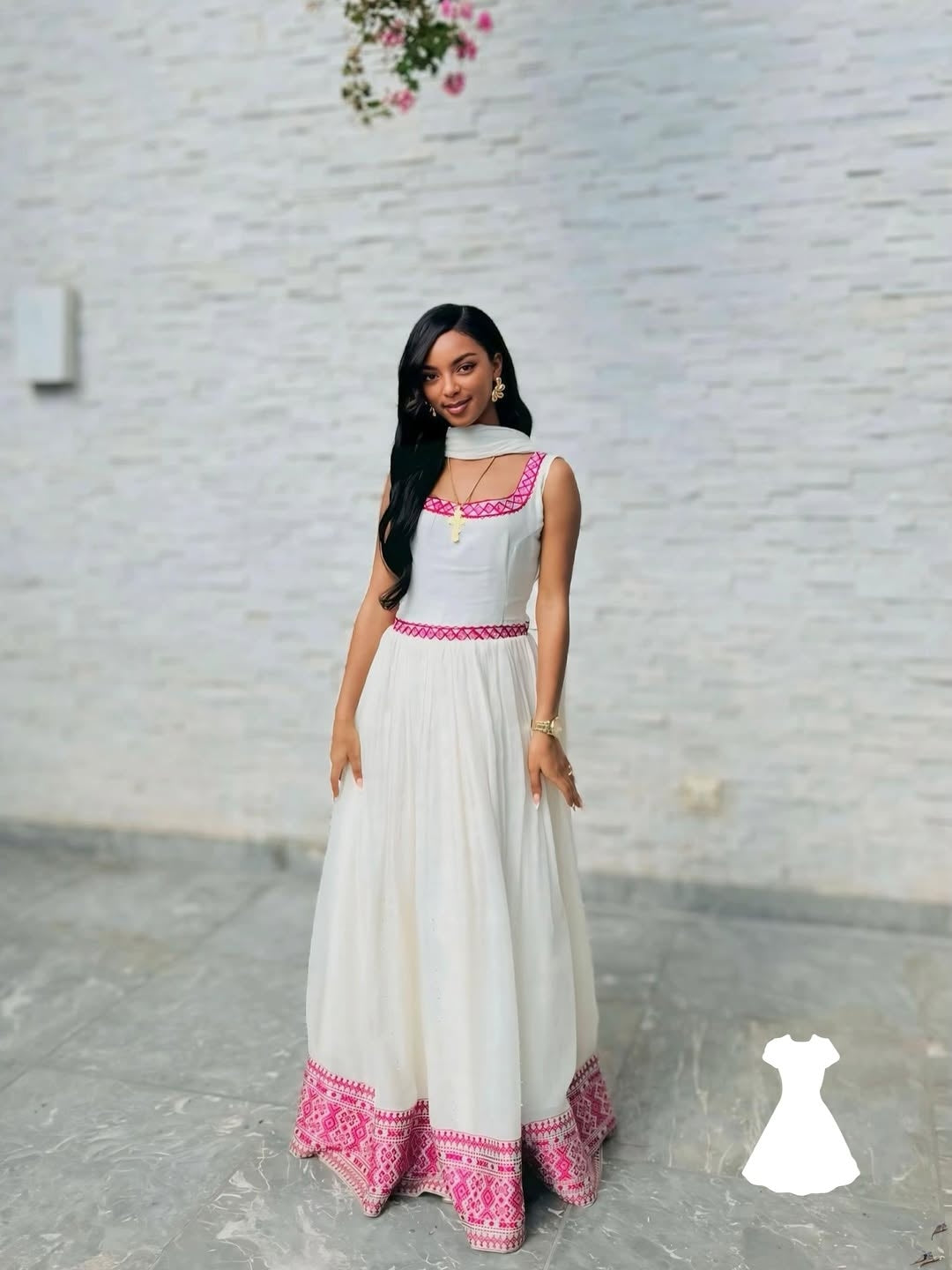 Woman wearing a white and pink traditional Ethiopian Kemis with a white background