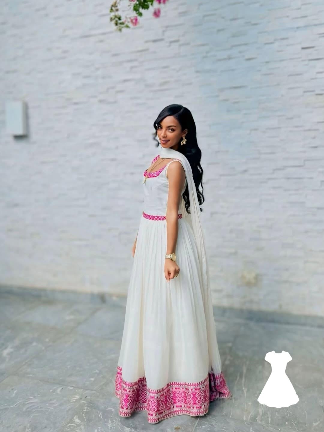 Woman wearing a white and pink traditional Ethiopian Kemis with a white background