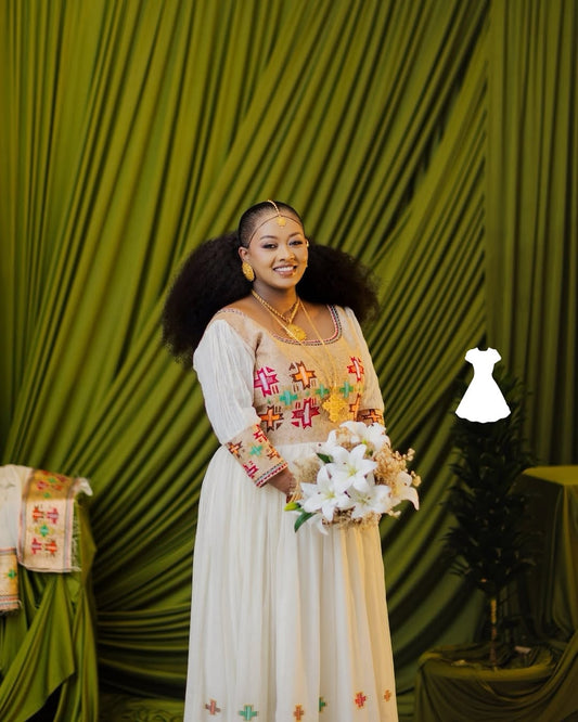 Woman in a Ethiopian Wedding Dress holding flowers against a green curtain backdrop