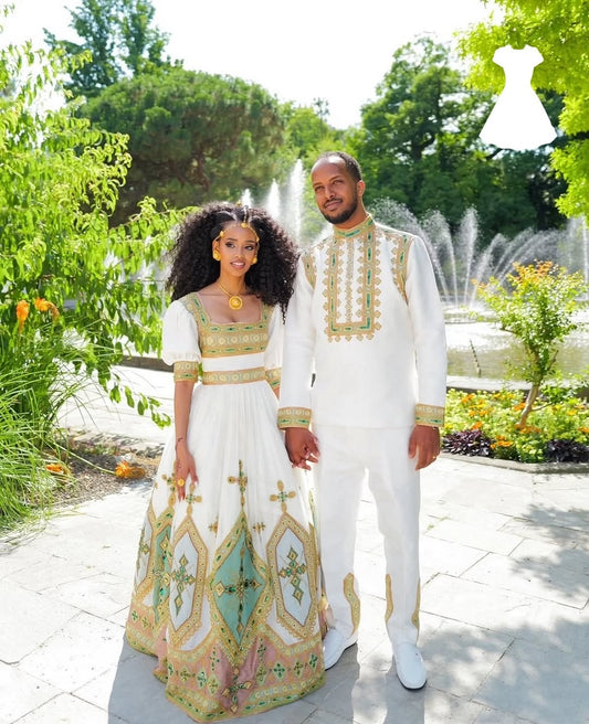Couple in formal Green Ethiopian Traditional Couple Set standing in a garden with a fountain in the background