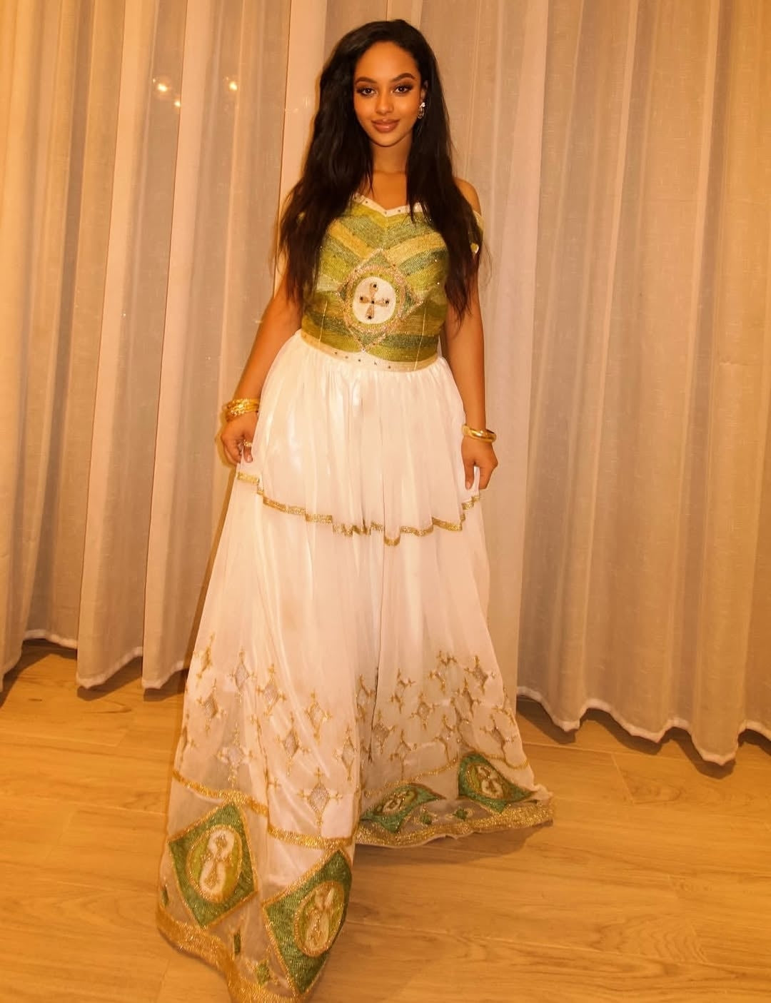 Woman wearing a traditional outfit with green and white Red Ethiopian Wedding Matching Set against a neutral background
