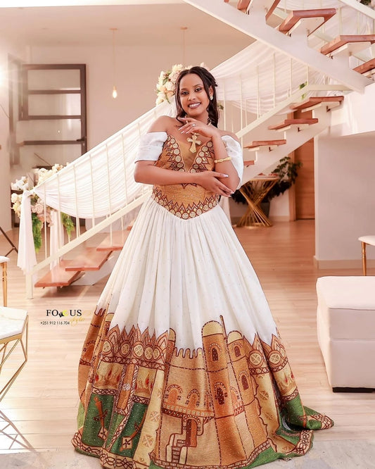 Woman in a traditional Habesha Wedding Dress with intricate patterns standing in a modern interior setting.
