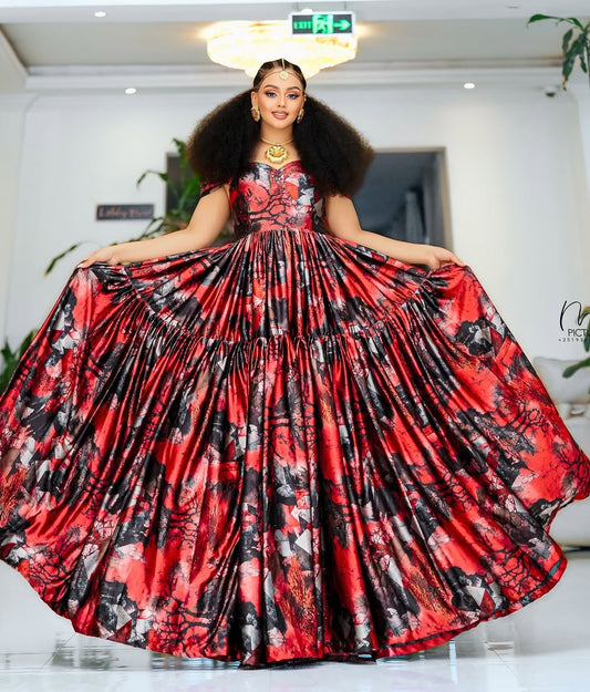 Woman in a red and black floral chiffion posing indoors.