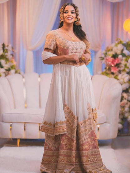 Woman in traditional outfit with floral decorations and white chairs in the background
