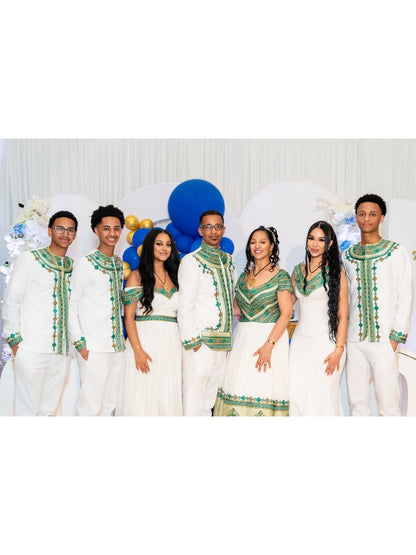 Seven people posing Green Habesha Family matching set in matching white traditional-style outfits with green embroidered trim, set against a white draped backdrop with blue balloons.