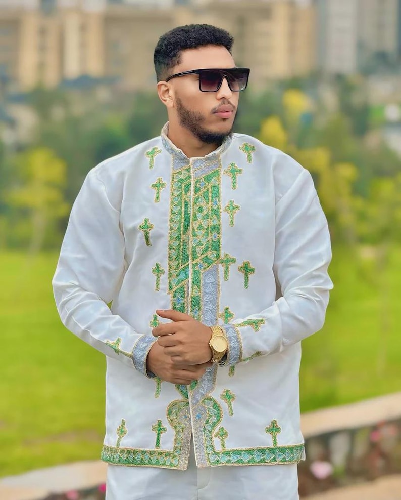 Man wearing a Men’s Habesha Shirt with green patterns outdoors
