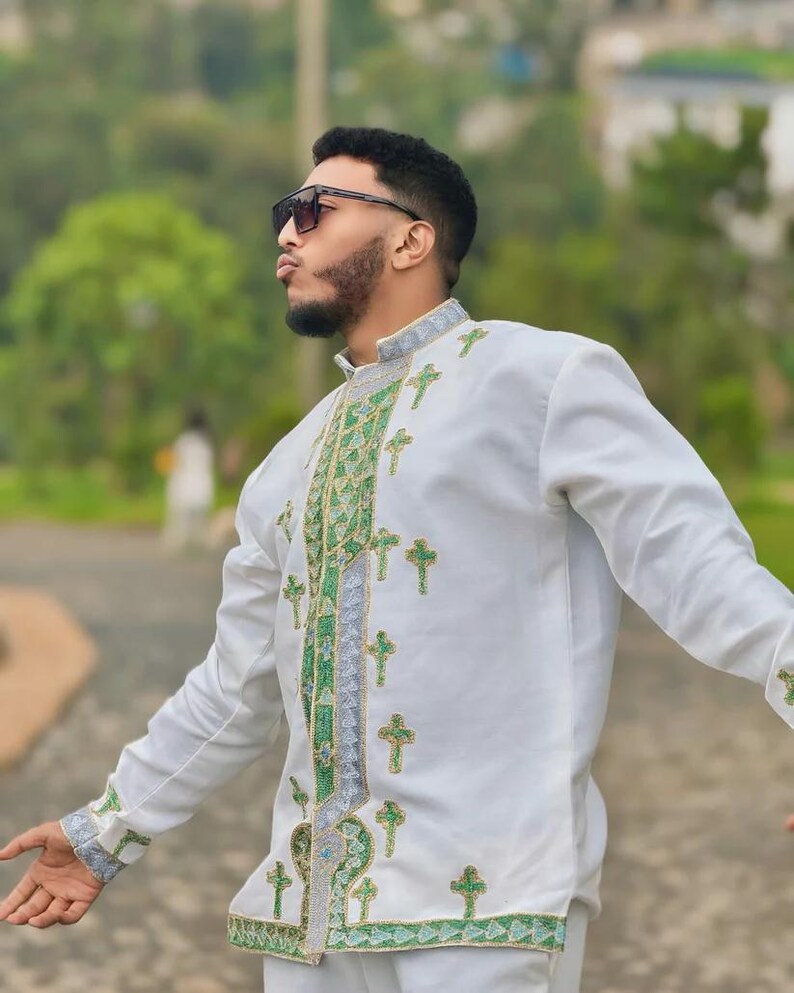 Man wearing Men’s Habesha Shirt embroidered shirt with green patterns outdoors