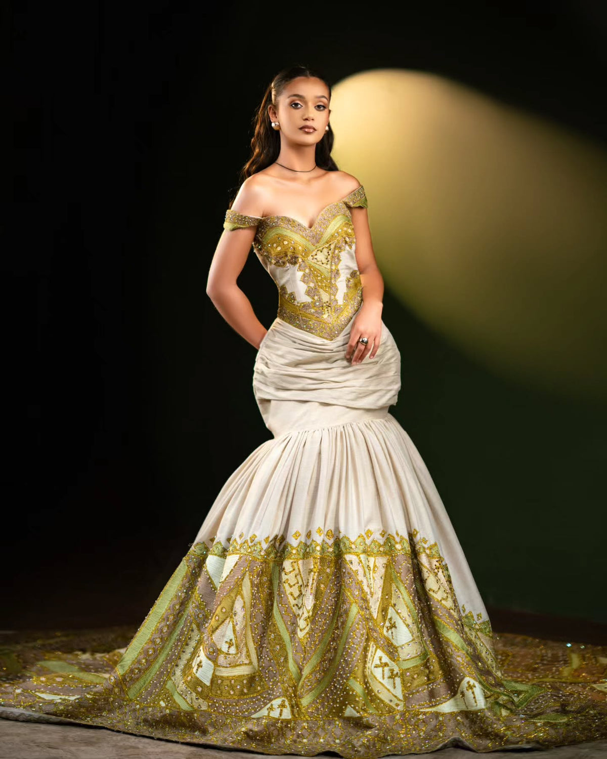 Woman wearing a green and white patterned Habesha Wedding Dress  on a dark background