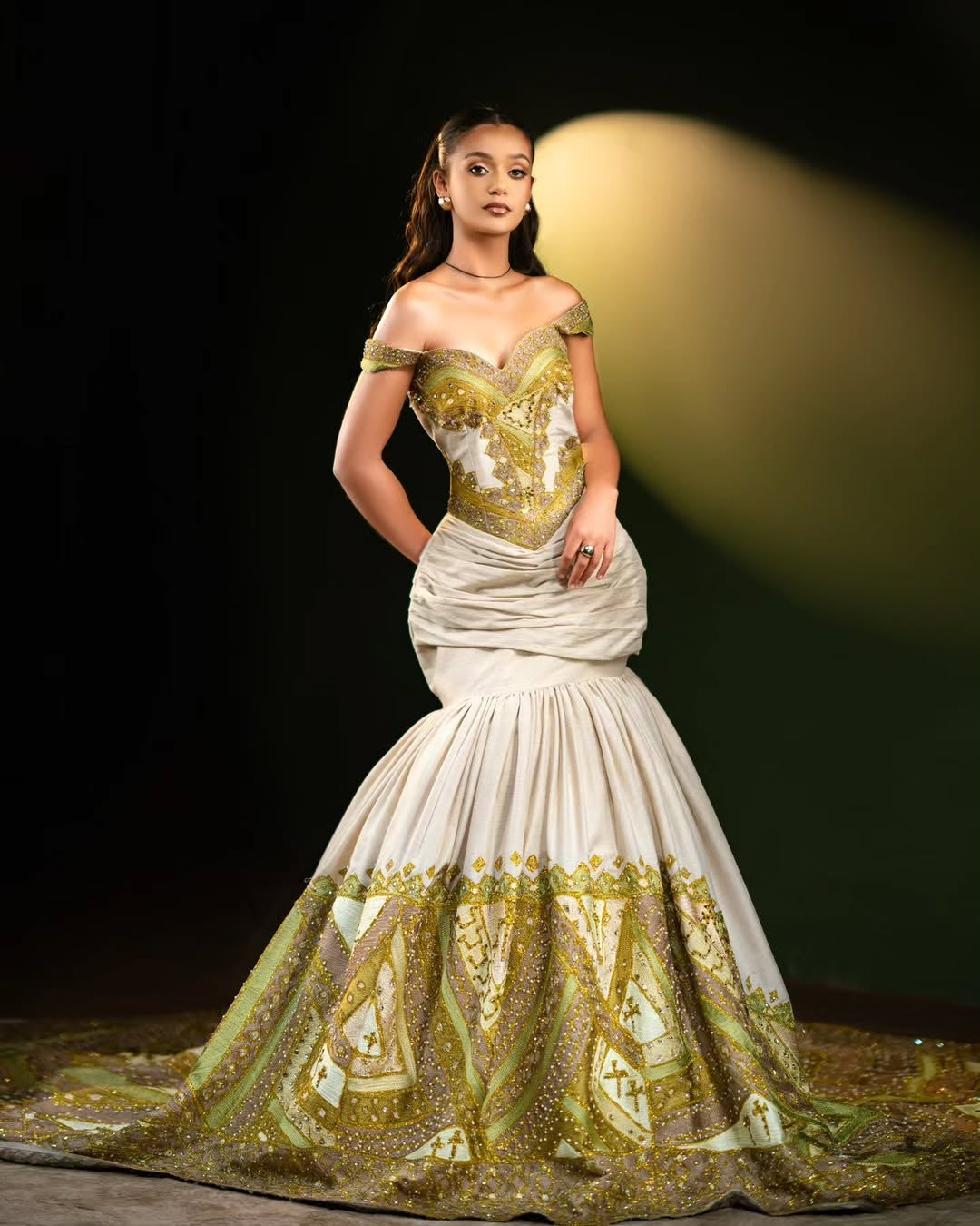 Woman wearing a green and white Green Mermaid Ethiopian Dress on a dark background