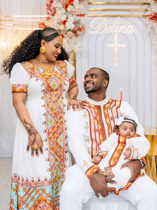 Family of three in matching Habesha Dress outfits with decorative background