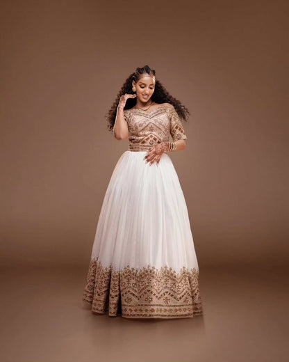 Woman wearing a traditional Habesha Kemis with gold embroidery on a brown background